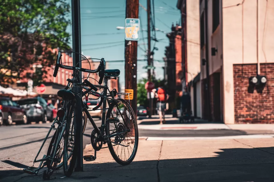 A pair of bikes are leaning against a street sign on an urban street in Philadelphia.